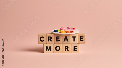 Wooden blocks spelling create more sit on a solid background with a paint palette.