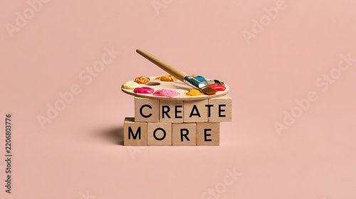 Wooden blocks spelling create more are topped with an artist palette and paintbrush.