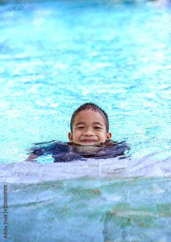 Portrait of a Happy Little Asian Boy Smiling in the Swimming Pool