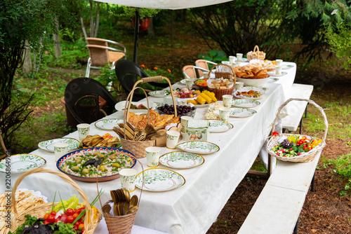 Festive outdoor buffet table surrounded by greenery