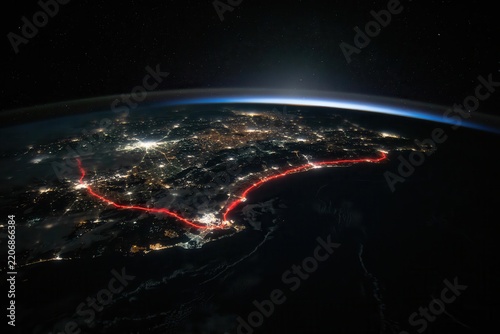 Nighttime Aerial View of Illuminated Coastal Cityscape from Earth Orbit