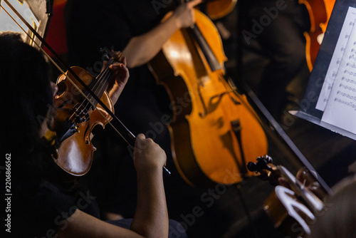 Musicians playing violin and cello close up during classical symphony orchestra performance