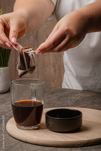 Female Hands Lifting Wet Drip Coffee Bag from Cup