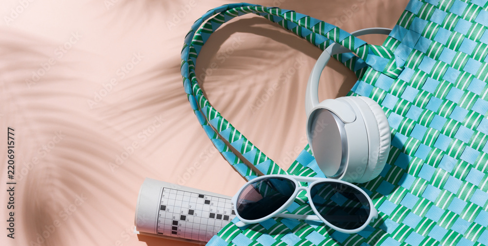 Obraz premium Turquoise Beach Bag with Headphones, Sunglasses and Crossword Puzzle