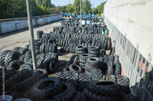 Large storage area with many tires stacked on the ground in a yard