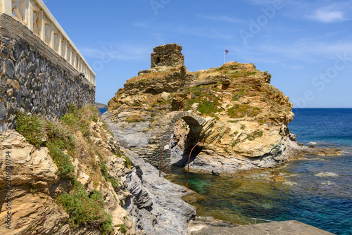The old arched stone bridge to the Venetian castle islet at Chora, Andros. Cyclades, Greece