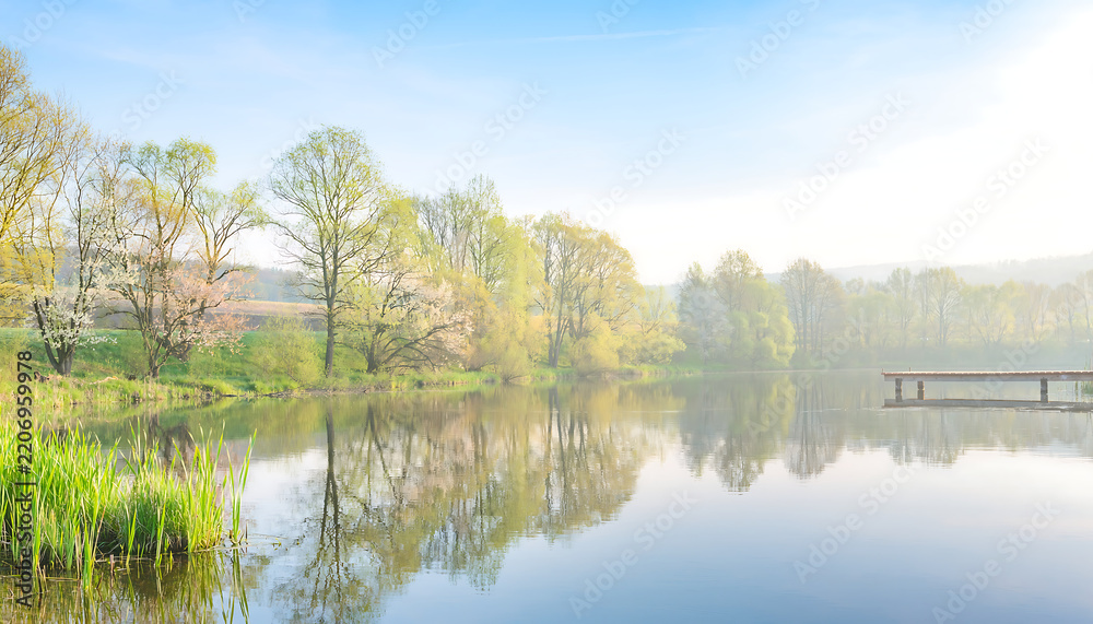 Fototapeta premium Serene lake landscape with trees, reflections and a wooden pier