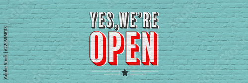 Yes we are open retro sign banner on brick background	