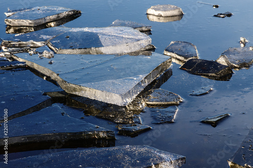 Fotografía Horizontal photograph of sharp broken ice slabs floating on smooth dark blue water surface