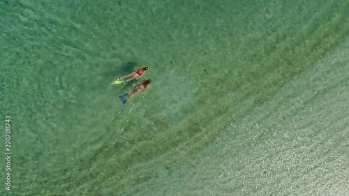 Two adults snorkeling side-by-side in crystal turquoise Pacific waters off Coiba Island, Panama, drone top view capturing tropical vacation, leisure and marine exploration - stock video