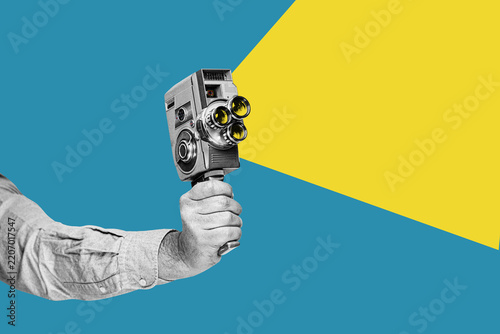 A hand holding retro film camera. Vintage cinema poster.