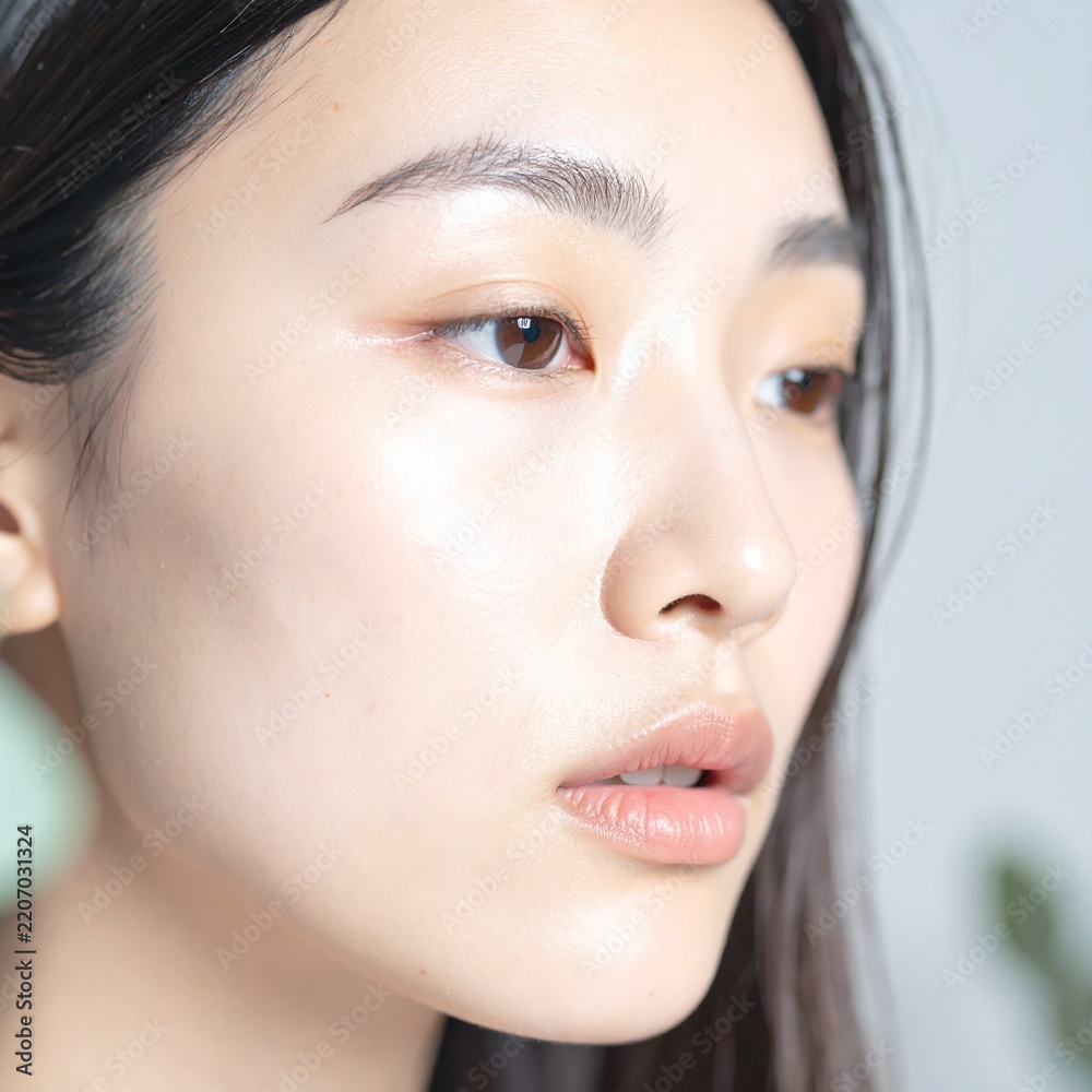 Obraz premium close up portrait of young beautiful asian woman exuding mystery, sadness