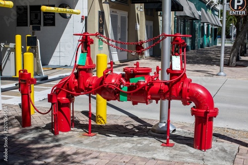 Red double check detector backflow preventer valve system for commercial building fire protection on a sidewalk