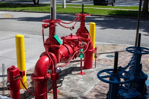 Red double check detector backflow preventer valve system for commercial building fire protection on a sidewalk
