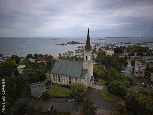 Obraz na plátně Aerial view of Hanko Church with high spire against coastal landscape and sea