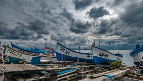 Fishing boats on the shore under dramatic stormy sky in Pomorie, Black Sea, Burgas, Bulgaria