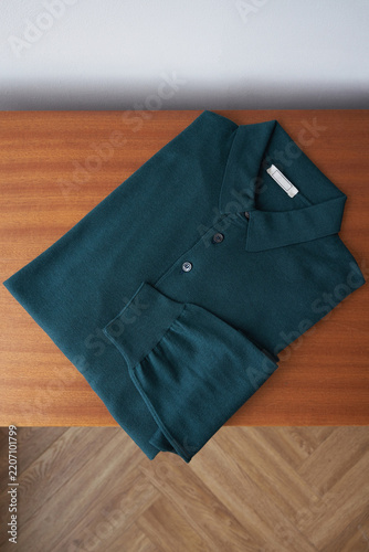 Polo shirt laying on a wooden table in a room
