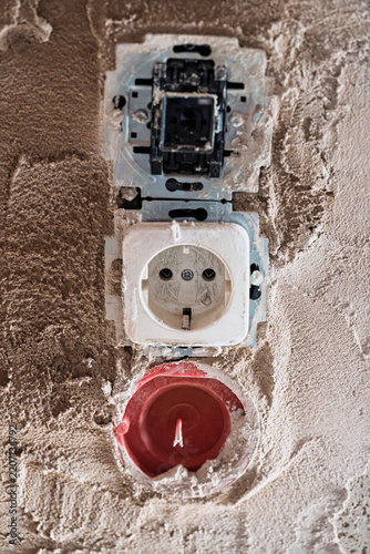 Closeup damaged wall outlets with exposed wiring, plaster debris views