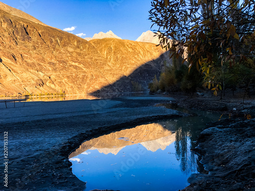 The golden Hindukush mirrored perfectly in crystal-clear waters