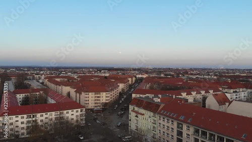 Aerial view of a city neighborhood with red roofs at dusk