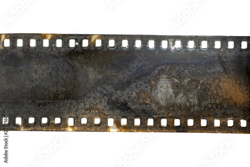 Damaged corroded 35mm film strip with perforations and residue