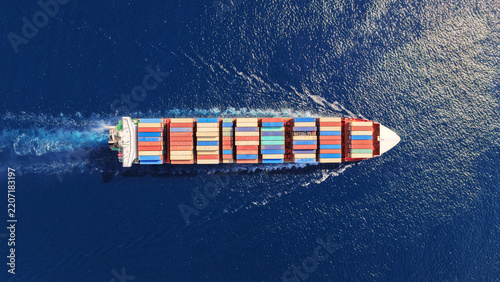 Aerial drone top down photo above huge size container ship cruising deep blue Mediterranean sea