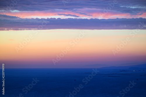 Pastel sunset over ocean with layered clouds