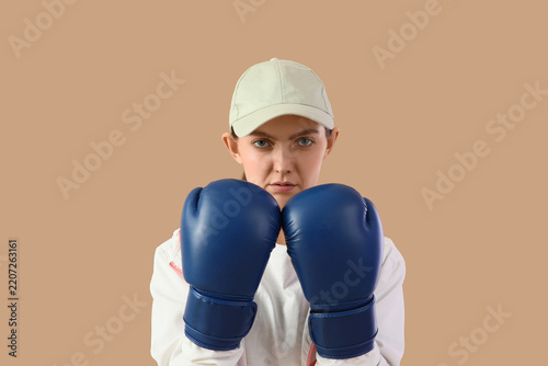 Obraz na plátně Empowerment and resilience, young woman wearing boxing gloves in a fighting stan
