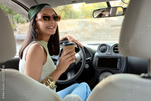 Commuter lifestyle and morning routine, happy woman driving car with coffee c...