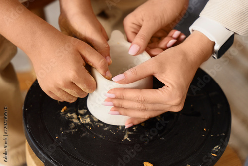 Parenting and child development, mother and child hands shaping clay on a pottery wheel for creative learning and family bonding activity at home