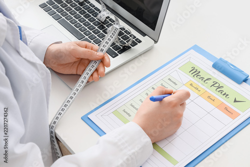 Weight loss and nutrition planning, nutritionist writing a healthy meal plan ...