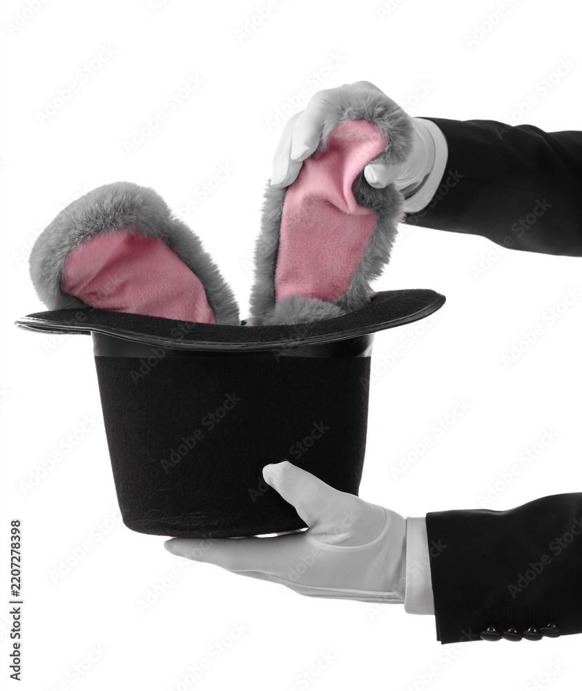 Obraz premium Magic trick and illusion, magician pulling fluffy rabbit ears from a black top hat for entertainment and performance art isolated on white background