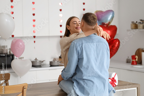 Valentines Day romance and love, happy young couple embracing in kitchen with...
