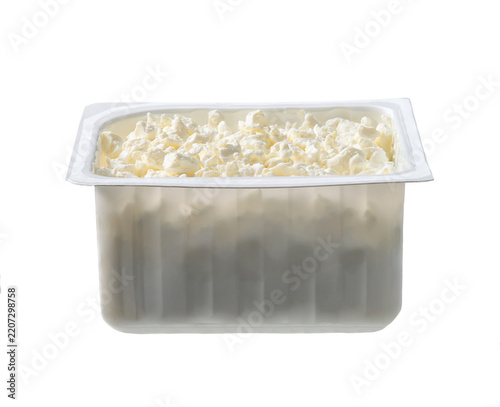 cottage cheese in a plastic box isolated on white background. Plastic tray of cottage cheese isolated on white background.
