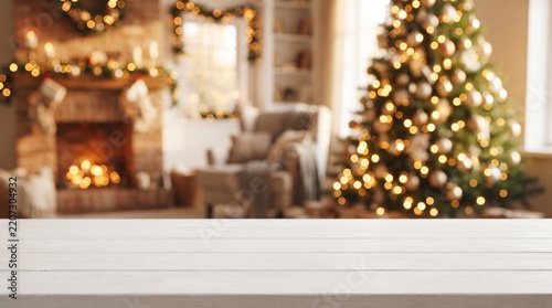 Blurred christmas tree and fireplace background on empty wooden tabletop, ideal for showcasing holiday season products