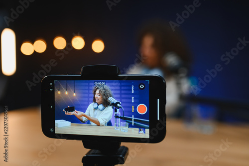 Vlogger presenting new smartphone during online broadcast recording video review