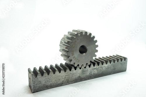 A steel spur gear resting on a matching rack gear