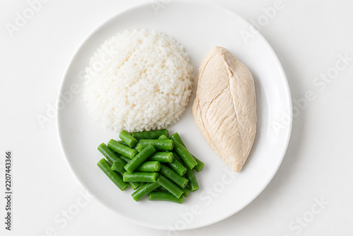 Flavorless bland diet meal, plain white plate with steamed rice, boiled chicken breast and unsalted green beans