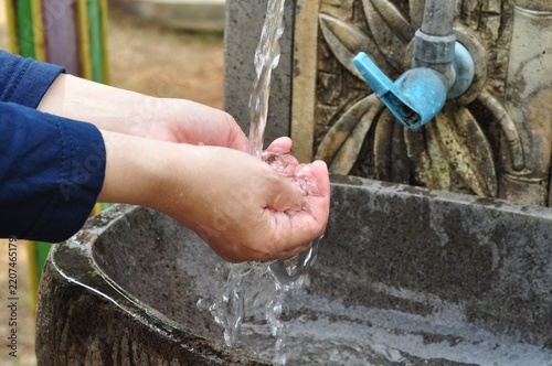 Close up of hands washing under running water outdoors