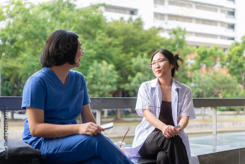 Obraz na plátně Young Asian female medical staff talking and relaxing outdoors at hospital, doct
