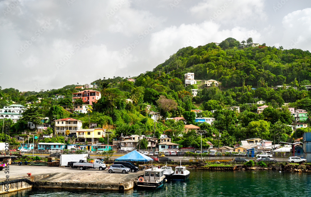 Obraz premium Waterfront pier with boats and colorful houses on a lush tropical hillside in Castries Harbour, Saint Lucia.