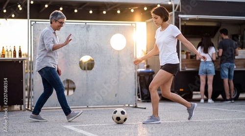 Young woman takes a run-up to kick a ball at a street festival