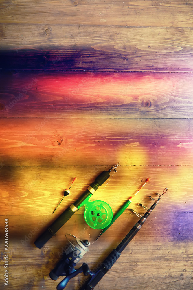 Fototapeta premium objects for fishing on a wooden pier close-up - hooks, baits, coil and hat