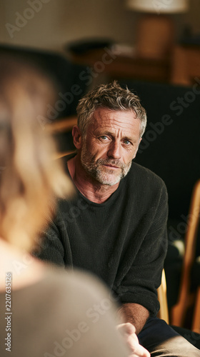 Introspective Gaze: A middle-aged man with a thoughtful expression and a grizzled beard gazes intently, perhaps in deep contemplation or a serious conversation.