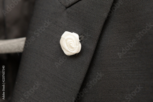 White rose lapel pin on black suit jacket