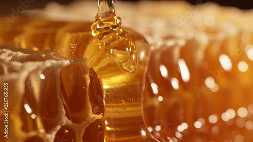 Macro of golden liquid honey and oil dripping over texture
