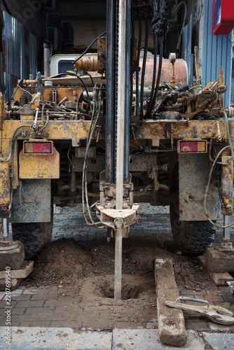 Geotechnical drilling rig borehole construction soil investigation hydraulic machinery working on urban ground for foundation testing and engineering.