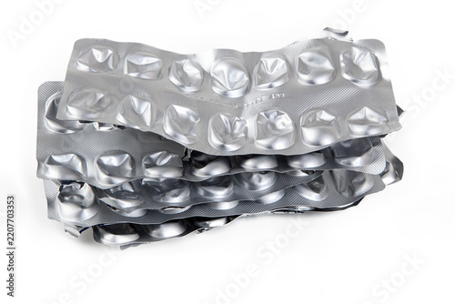 Used and empty aluminum blister packs for tablets and medications. Medical waste. Concept of empty packaging on a white background. Aluminum and plastic recycling.