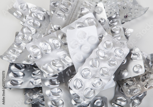 Used and empty aluminum blister packs for tablets and medications. Medical waste. Concept of empty packaging on a white background. Aluminum and plastic recycling.