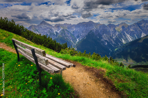 Mountain landscape with wooden bench and alpine valley